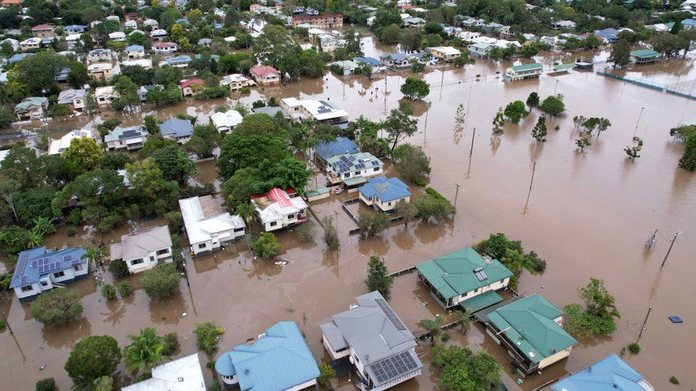 An aerial drone view of houses surrounded by floodwater in Lismore