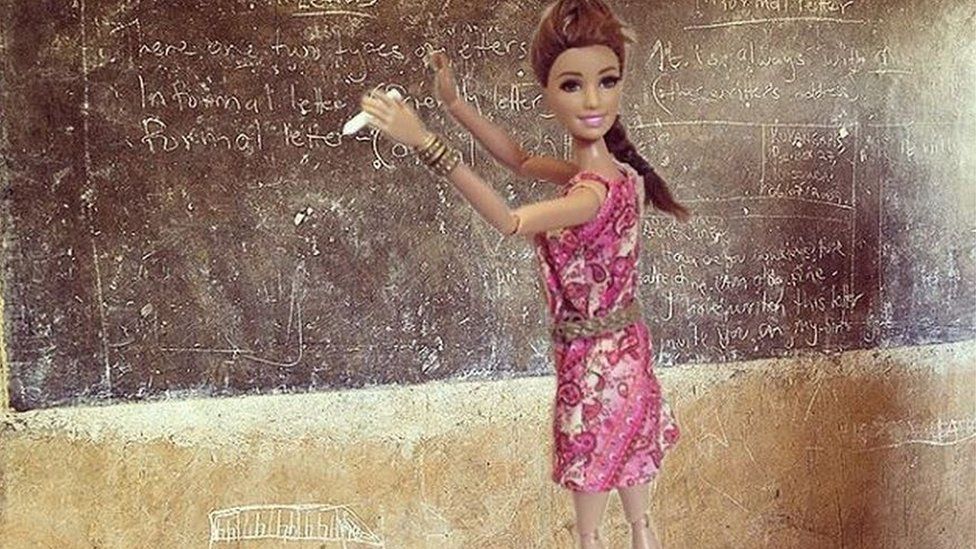 Barbie in front of a blackboard
