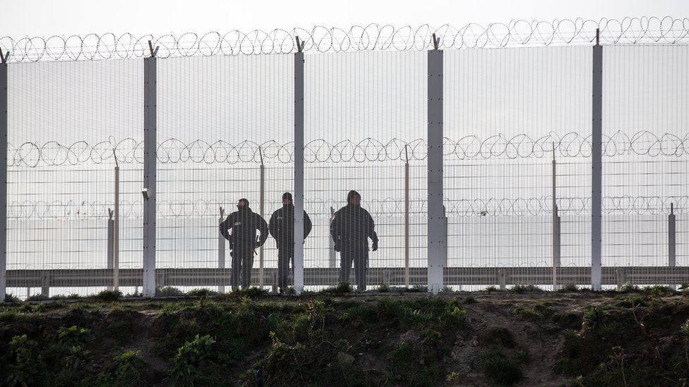 French police behind a fence near Calais