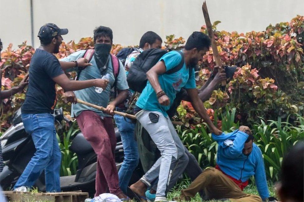 Сторонники правительства избивают антиправительственного протестующего во время столкновений возле дома премьер-министра в Коломбо, Шри-Ланка, 9 мая 2022 г.