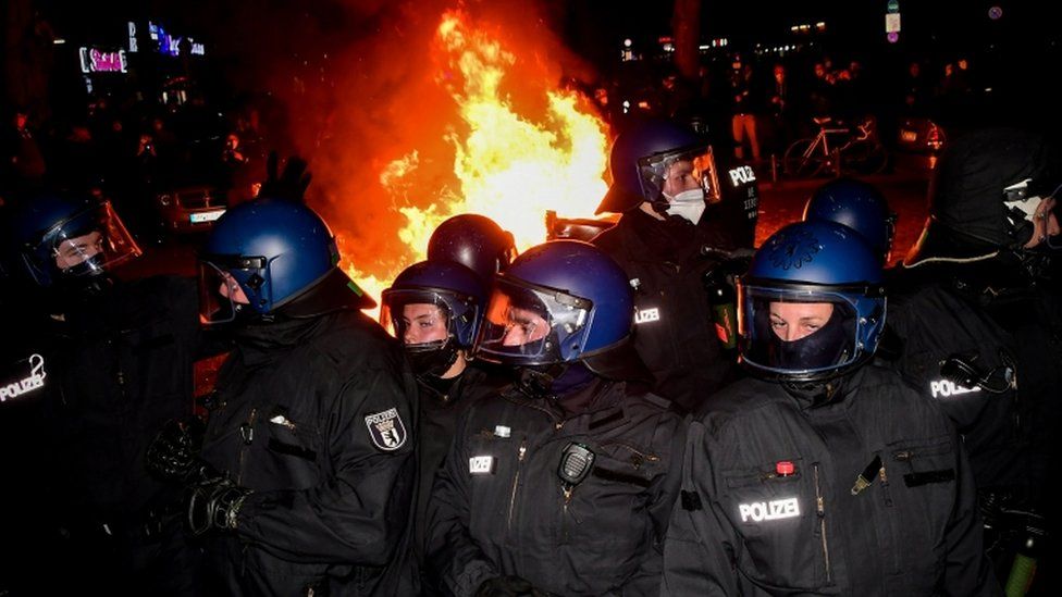 Riot police take position next to a burning barricade during a protest on May Day in Berlin, Germany