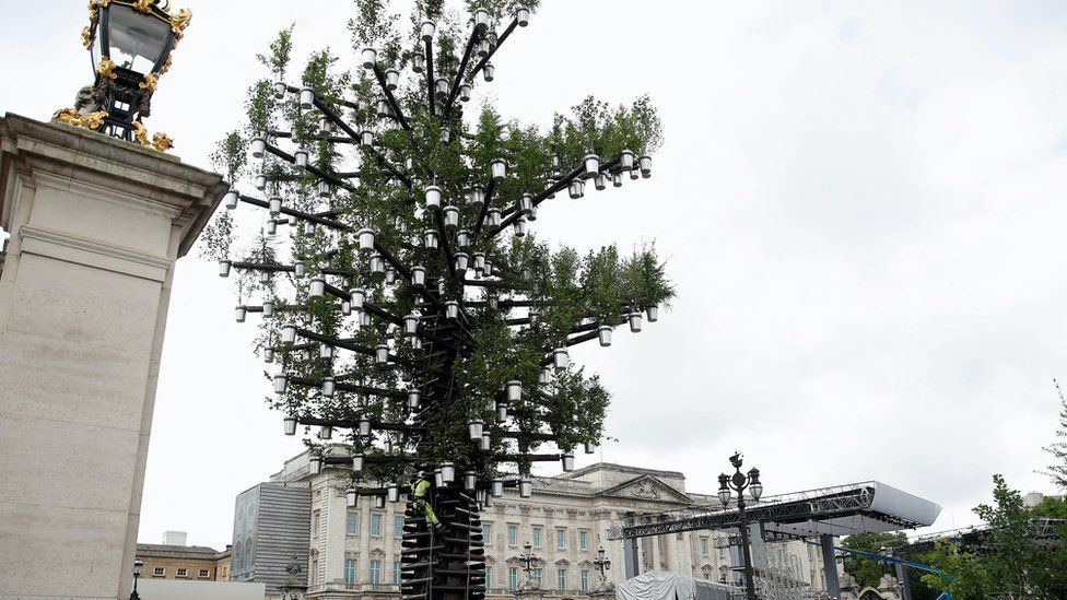 The Trees of Trees sculpture standing outside Buckingham Palace with metal pots hanging from the tree