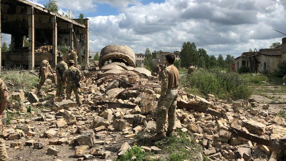 Marines stood among rubble and debris
