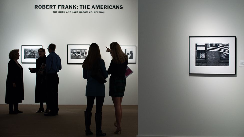 People look at rare Robert Frank photographs from his book "The Americans" at Sotheby's on 17 December 2015 in New York City.