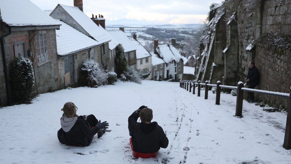 Children sledging on Gold Hill in Shaftesbury, Dorset