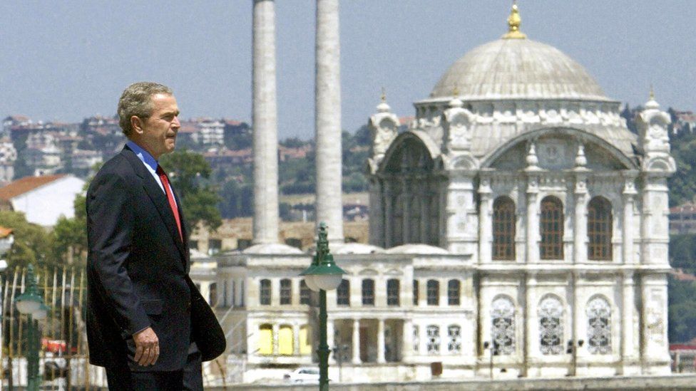 George W Bush walks in Istanbul with a mosque in the background