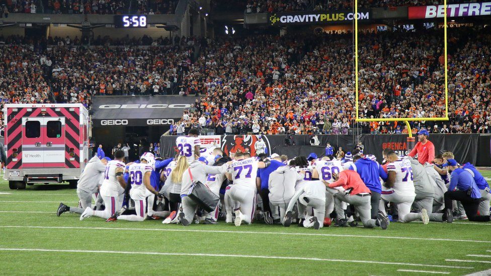 Buffalo Bills players kneel to pray as the ambulance carrying teammate Buffalo Bills safety Damar Hamlin (not pictured) leaves the playing field during the first quarter against the Cincinnati Bengals at Paycor Stadium. Mandatory Credit: Joseph Maiorana-USA TODAY Sports