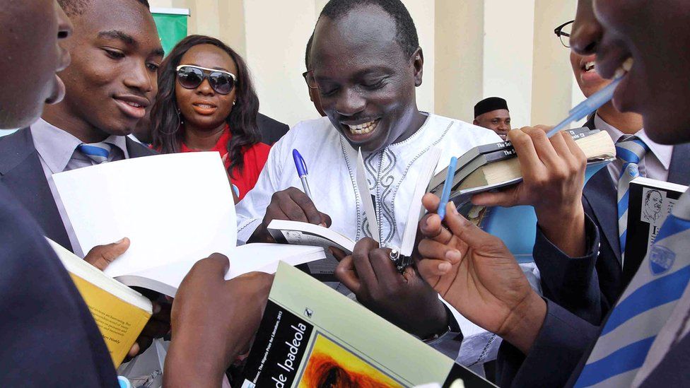 Nigerian poet Tade Ipadeola signs books after he was awarded with the prestigious Nigeria Prize for Literature during a ceremony in Lagos on 6 March 2014