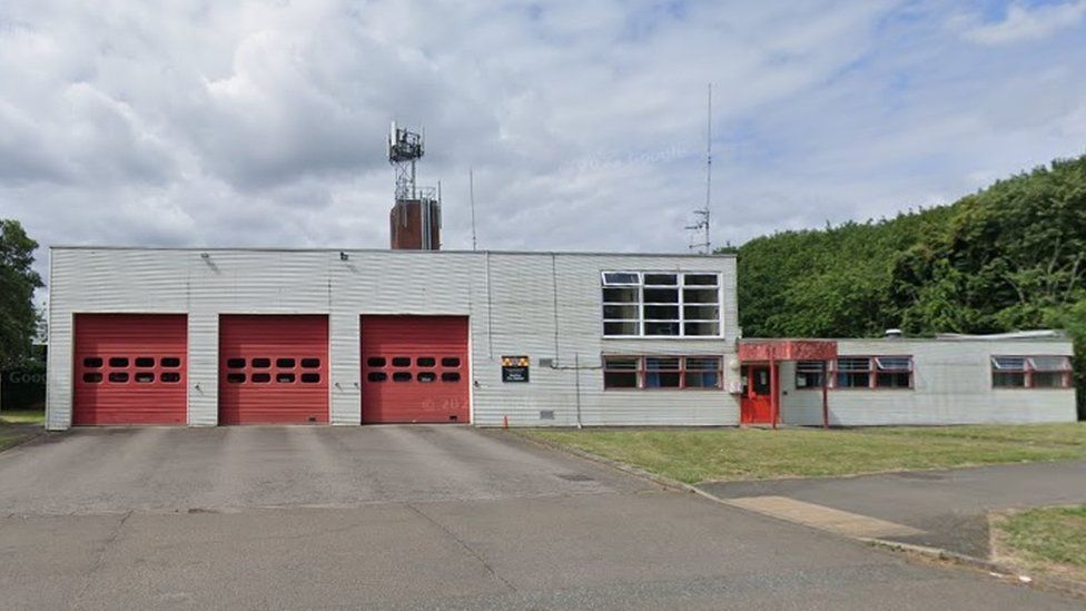 Concrete fire station building with three garage doors