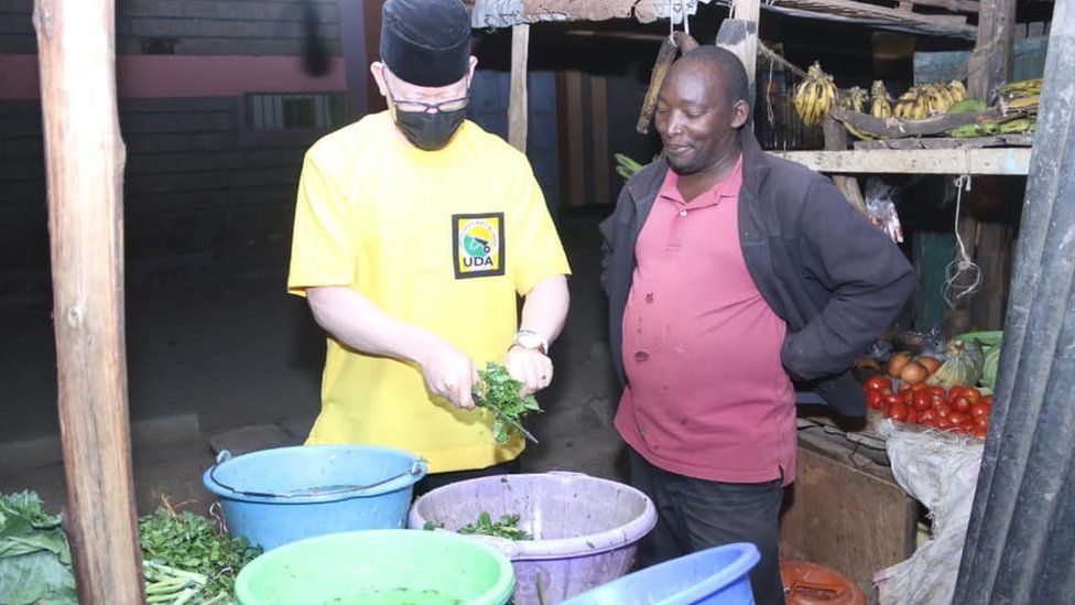 Senator Isaac Mwaura (in yellow) chopping vegetables