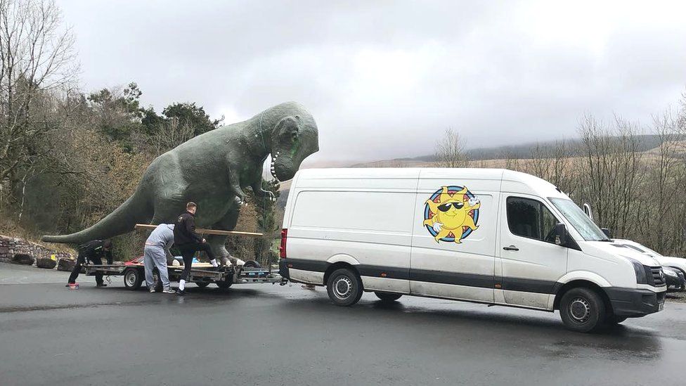 A team loading the dinosaur on to the trailer