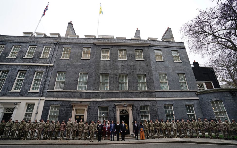 Premierminister Rishi Sunak zusammen mit dem ukrainischen Botschafter in Großbritannien, Vadym Prystaiko, seiner Frau Inna Prustaiko, Mitgliedern der ukrainischen Streitkräfte und Vertretern aller Interflex-Nationen vor der Downing Street 10 in London, 24. Februar 2023.