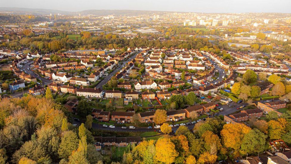 The rising sun illuminates a housing estate dotted with autumnal trees in the St Annes area of east Bristol