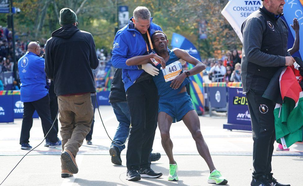 Girma Bekele Gebre of Ethiopia is helped during the Professional Men's Finish during the 2019 TCS New York City Marathon in New York on November 3, 2019.