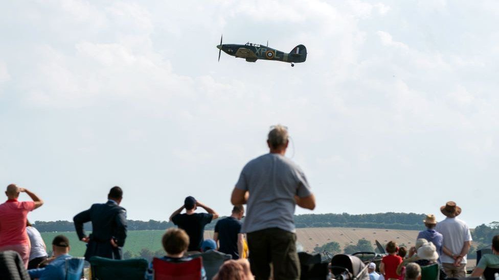 Hawker Hurricane IIB BE505 flying during the Battle of Britain Air Show at IWM Duxford. A crowd of people watch on.