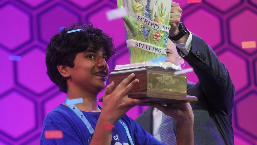 Dev Shah, 14, receives the trophy after winning the Scripps National Spelling Bee competition
