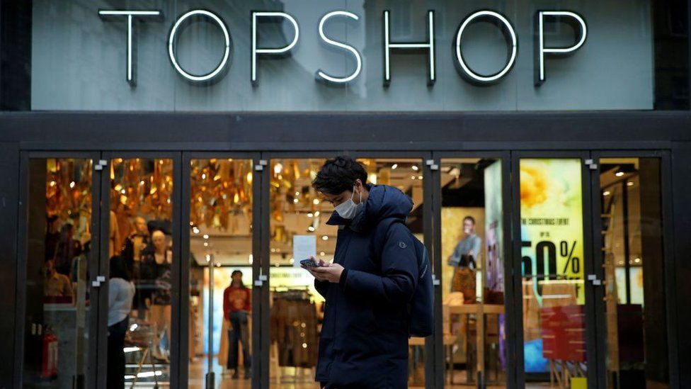 Man standing outside Topshop wearing face mask