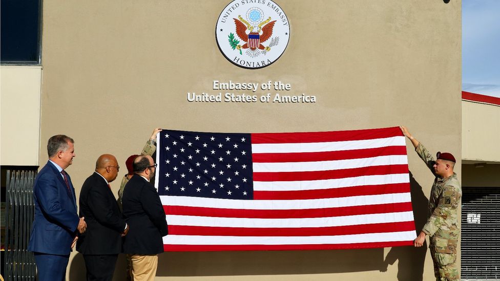 Dignitaries watch on as an American flag is unfurled outside the US embassy in Honiara during its opening on 27/1