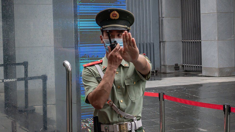 A Chinese police officer gestures "stop" outside the Australian embassy in Beijing in July 2020