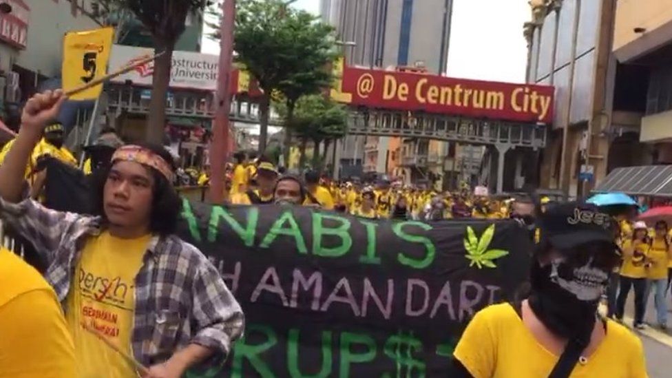 Protesters at a rally carry a sign calling for tough penalties against cannabis possession to be scrapped