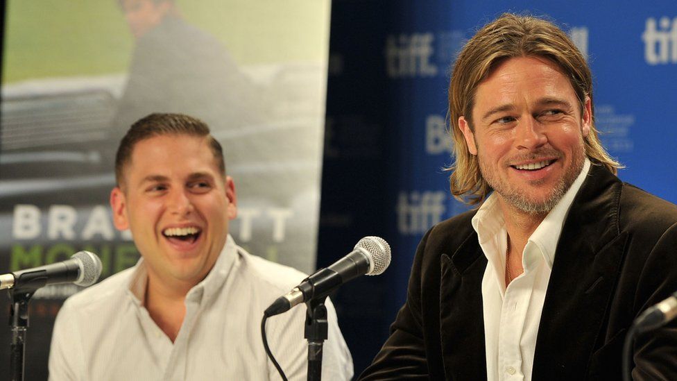 Jonah Hill and Brad Pitt speak onstage at "Moneyball" Press Conference during 2011