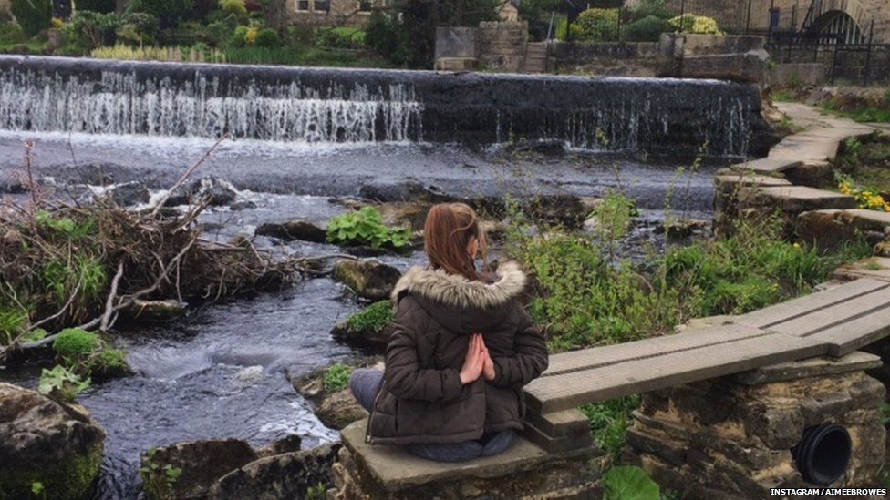 Aimee Browes practising yoga near a waterfall