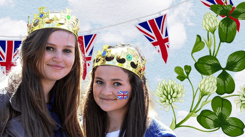 Two women wearing crowns against a background of union jack bunting