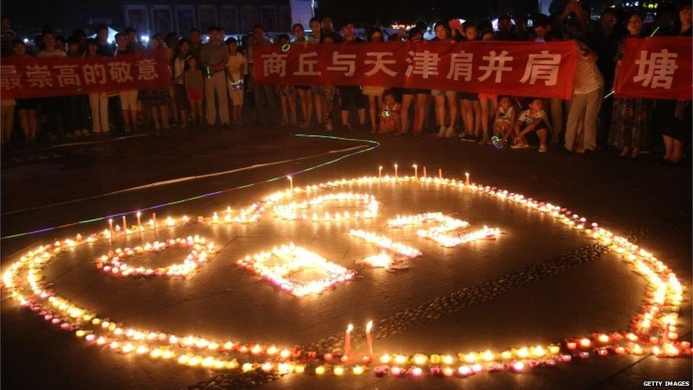 Citizens light candles to mourn those who died in the warehouse explosion