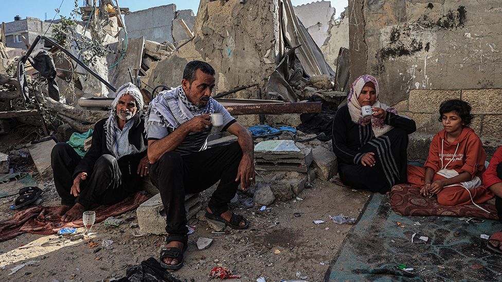 Family drink tea in rubble of a building in Rafah