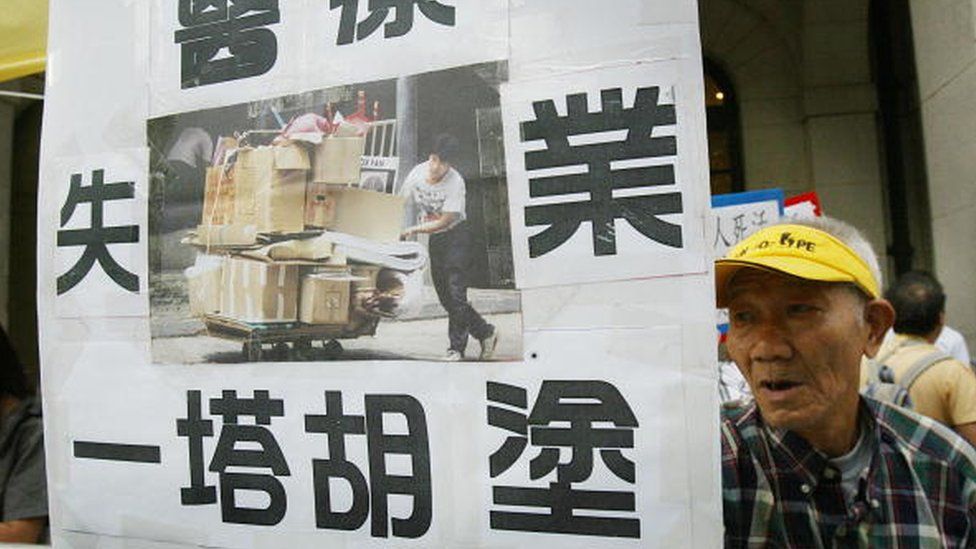 An elderly man protesting against collecting cardboard