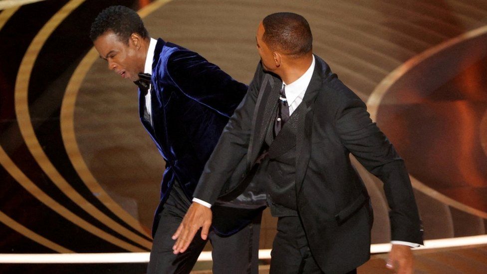 Will Smith (R) hits Chris Rock as Rock spoke on stage during the 94th Academy Awards in Hollywood, Los Angeles, California