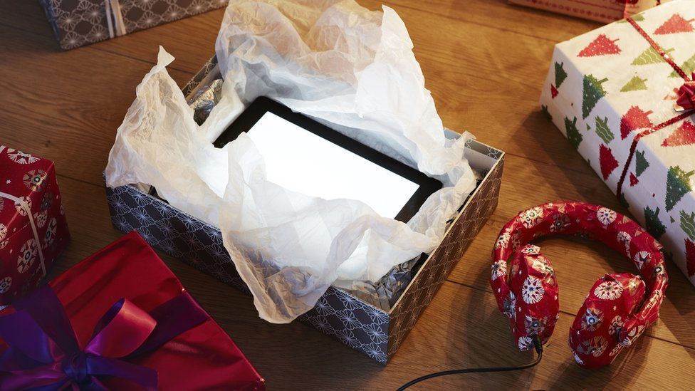 Таблетку открывают из рождественской подарочной коробки, рядом есть еще подарки