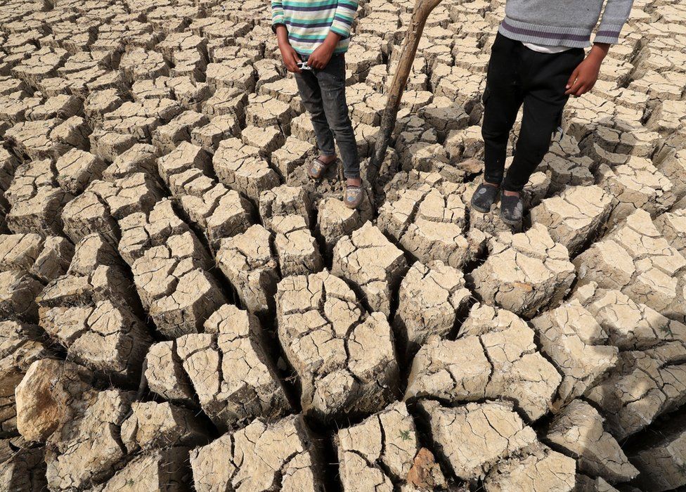 Children stand on a dry and cracked ground at the Chiba dam in the governorate of Nabeul, Tunisia, 01 April 2023.