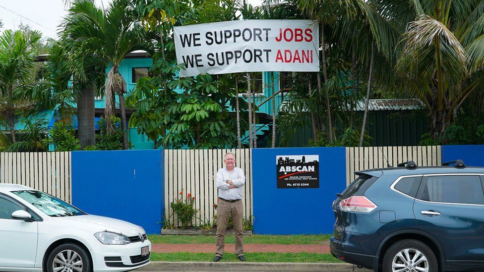 Steve Malcolm in front of a banner supporting Adani coal mine
