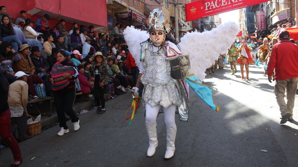 A participant with angel's wings parades through the streets