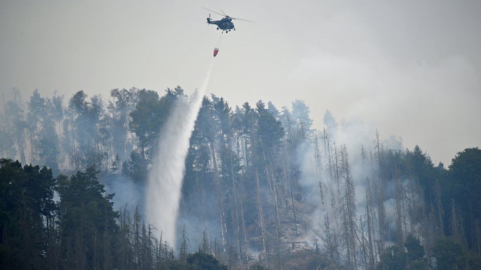A Czech army helicopter helps to extinguish a forest fire, during a heatwave, close to the German-Czech border near Schmilka, Germany, July 26, 2022.