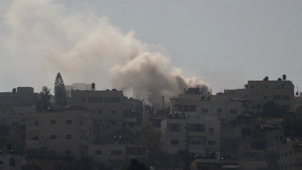 Smoke rises over houses during an Israeli raid in Jenin, in the occupied West Bank (12 December 2023)