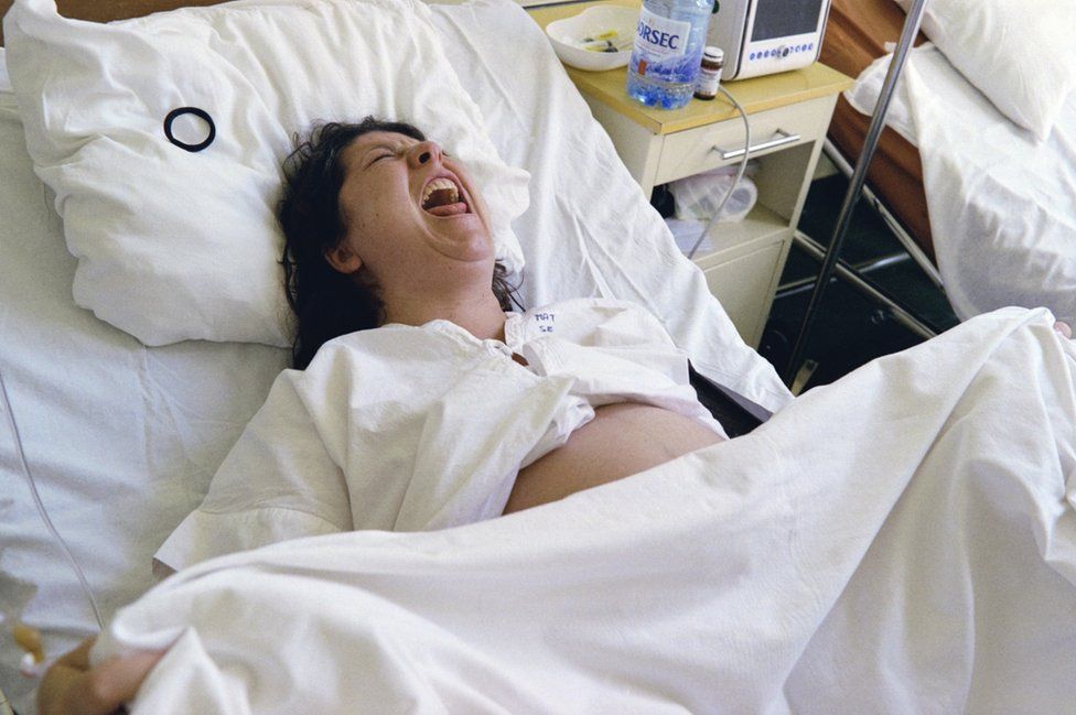 Roxana having a contraction during the early stages of the birth of her daughter at a specialist clinic in Bucharest. She later had a C Section.