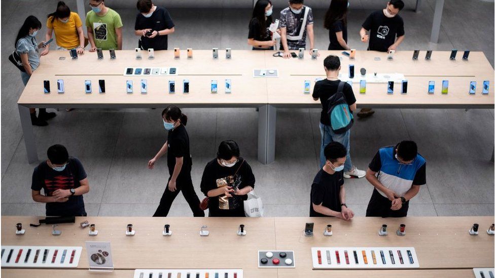 Люди смотрят на смартфоны, выставленные во флагманском магазине Huawei в Шэньчжэне