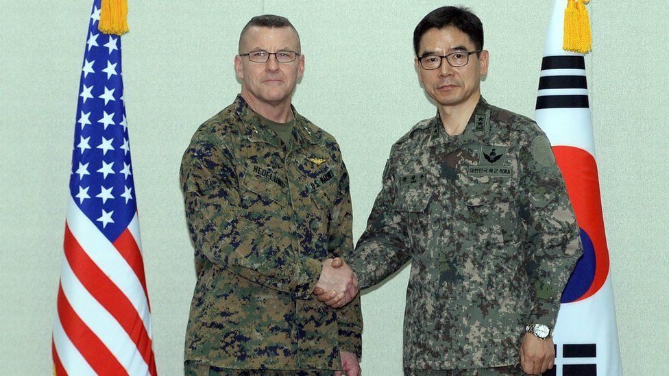 South Korea's Major General Jang Kyung-soo (R) and US Forces Korea Major General Robert Hedelund shake hands at the Defense Ministry in Seoul