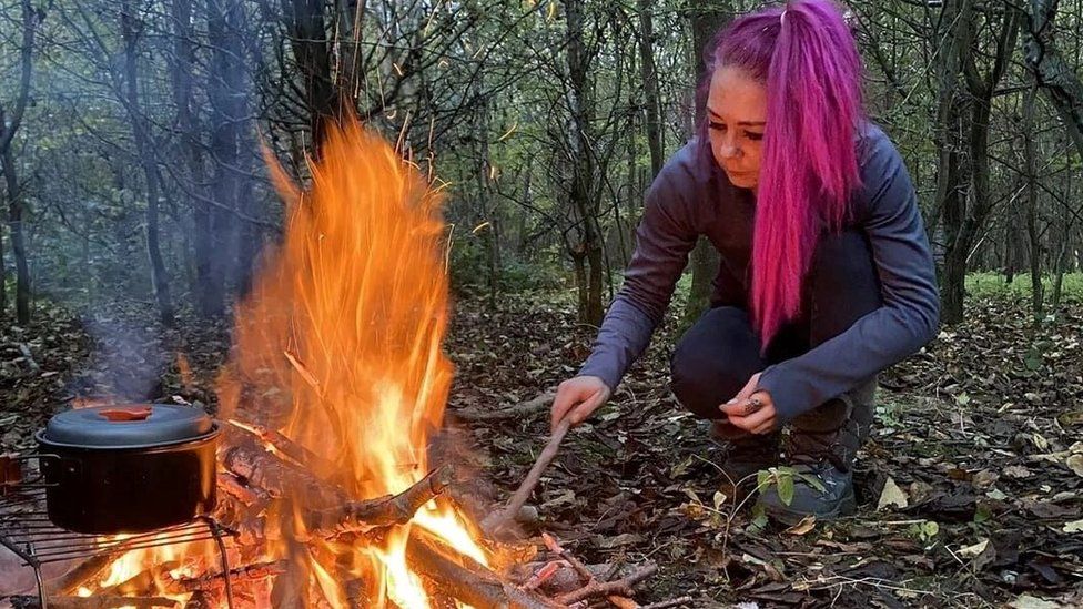Kady Hughes lighting a fire