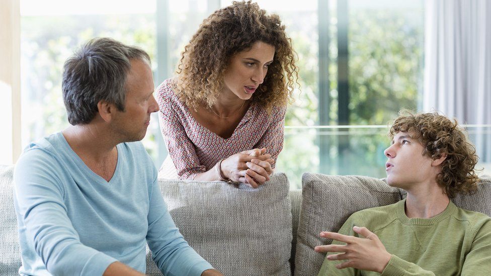 A stock image of parents talking to teenage son