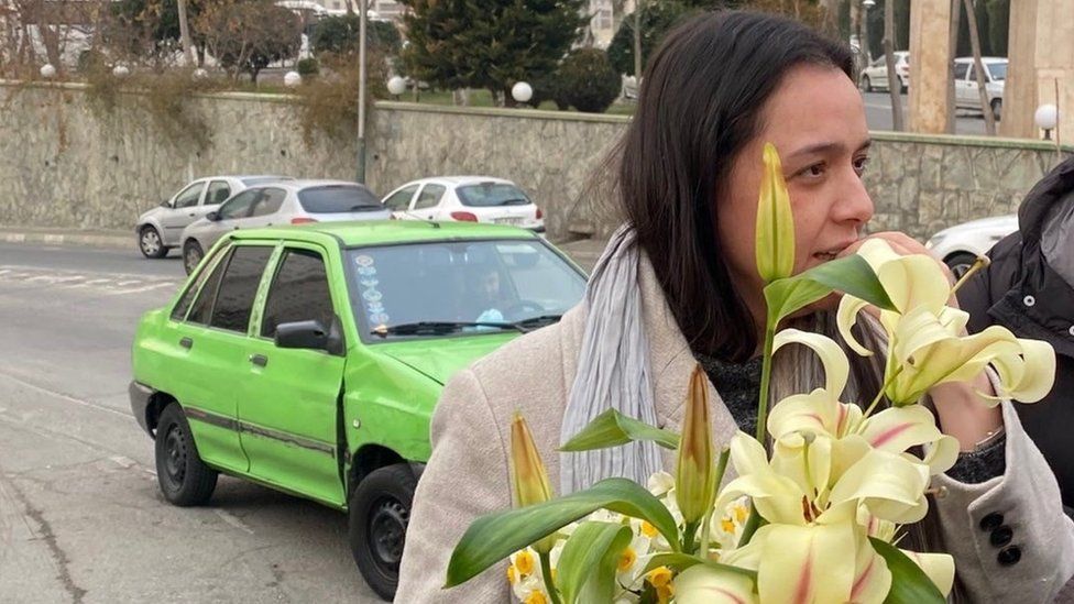 Iranian actress Taraneh Alidoosti holds a bouquet of flowers outside Tehran's Evin prison after being released on bail (4 January 2023)