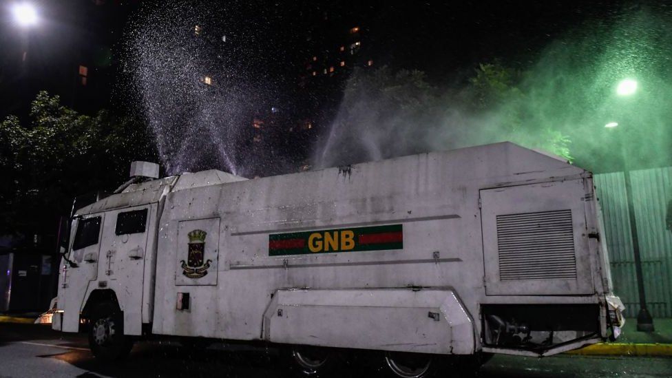 A riot vehicle sprays decontaminant on the streets of Caracas, 30 March