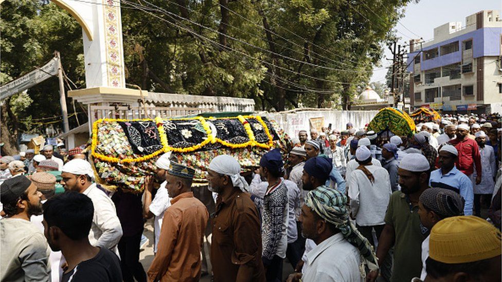 Люди присутствуют на церемонии похорон тех, кто погиб в результате аварии на мосту после обрушения моста через реку Маччху в Морби в индийском штате Гуджарат 31 октября 2022 года. (