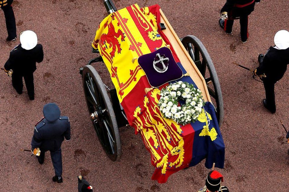 An overhead view of the Queen's coffin being carried on the gun carriage, with her crown resting on it