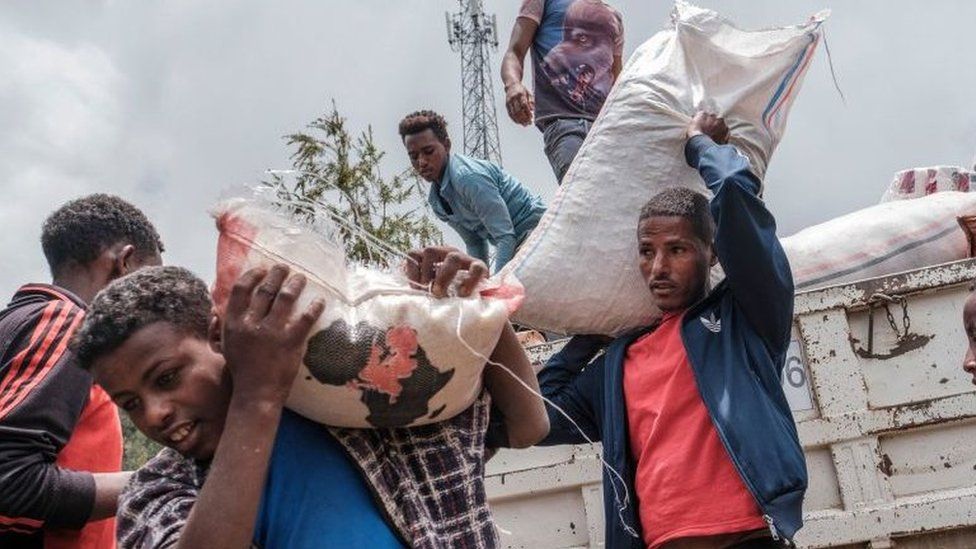 Civilians displaced by fighting in northern Ethiopia off load food and supplies from a truck, provided by the local population, at the Addis Fana School where they are temporary sheltered, in the city of Dessie, Ethiopia, on August 23, 2021