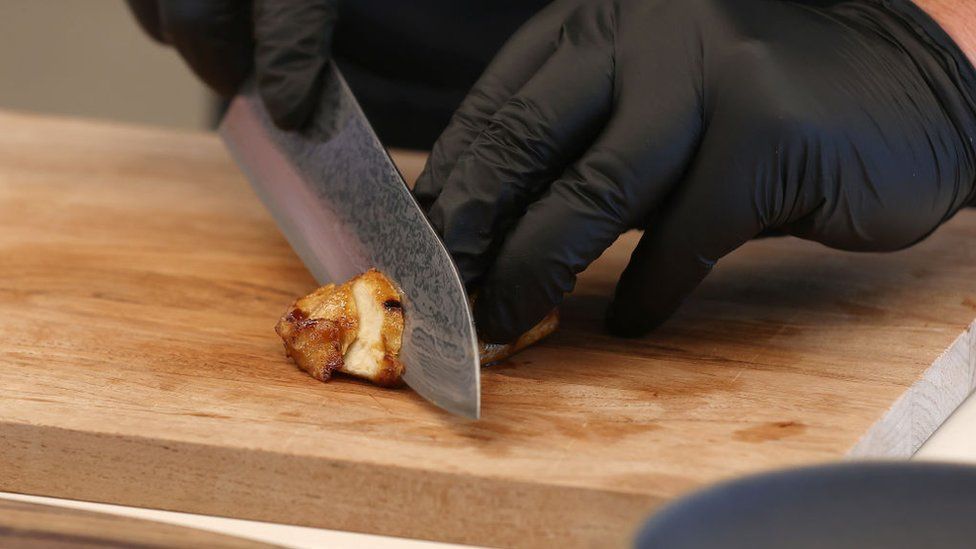Chef Nate Park slices a piece of Good Meat's cultivated chicken at the Eat Just office on July 27, 2023 in Alameda, California
