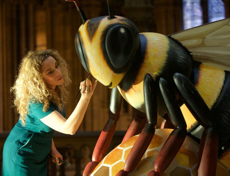 Artist Jodie Silverman puts the finishing touches to one of the bee sculptures
