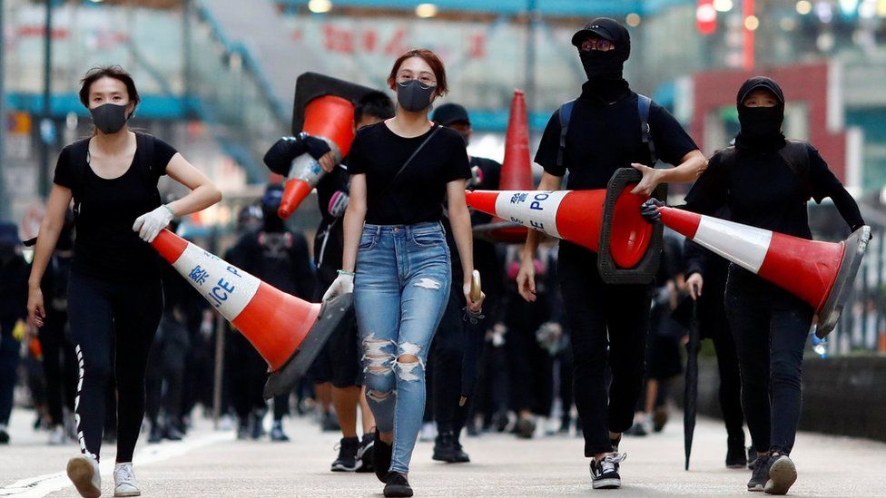 Protesters walk down the road with traffic cones to build a barricade in Causeway Bay, Hong Kong, China November 11, 2019